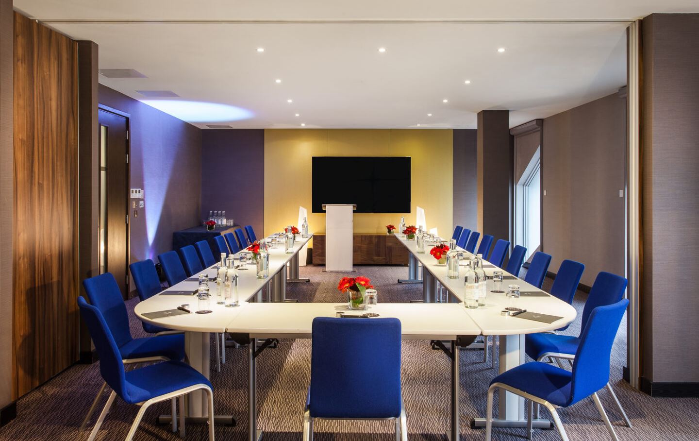 Modern meeting room with U-shaped table, ideal for workshops and professional gatherings.