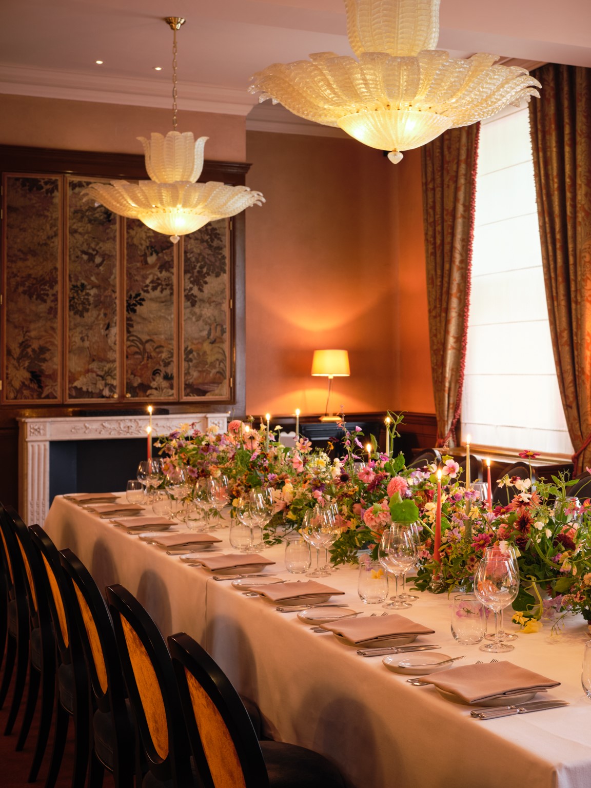 Elegant dining table with floral arrangements at The NoMad London for corporate events.