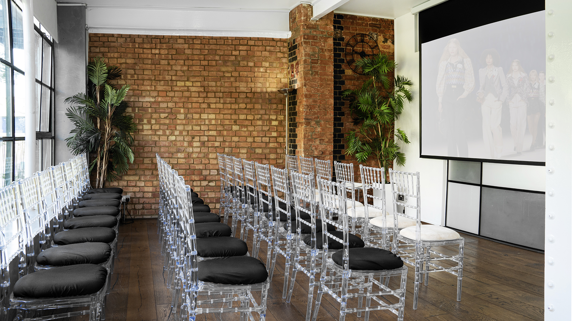 Modern event space with acrylic chairs for presentations in S1 Apartment.