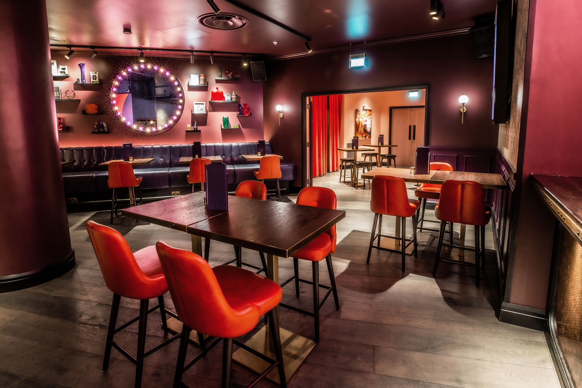 Stylish event space at Puttshack Bank with vibrant orange chairs for gatherings.