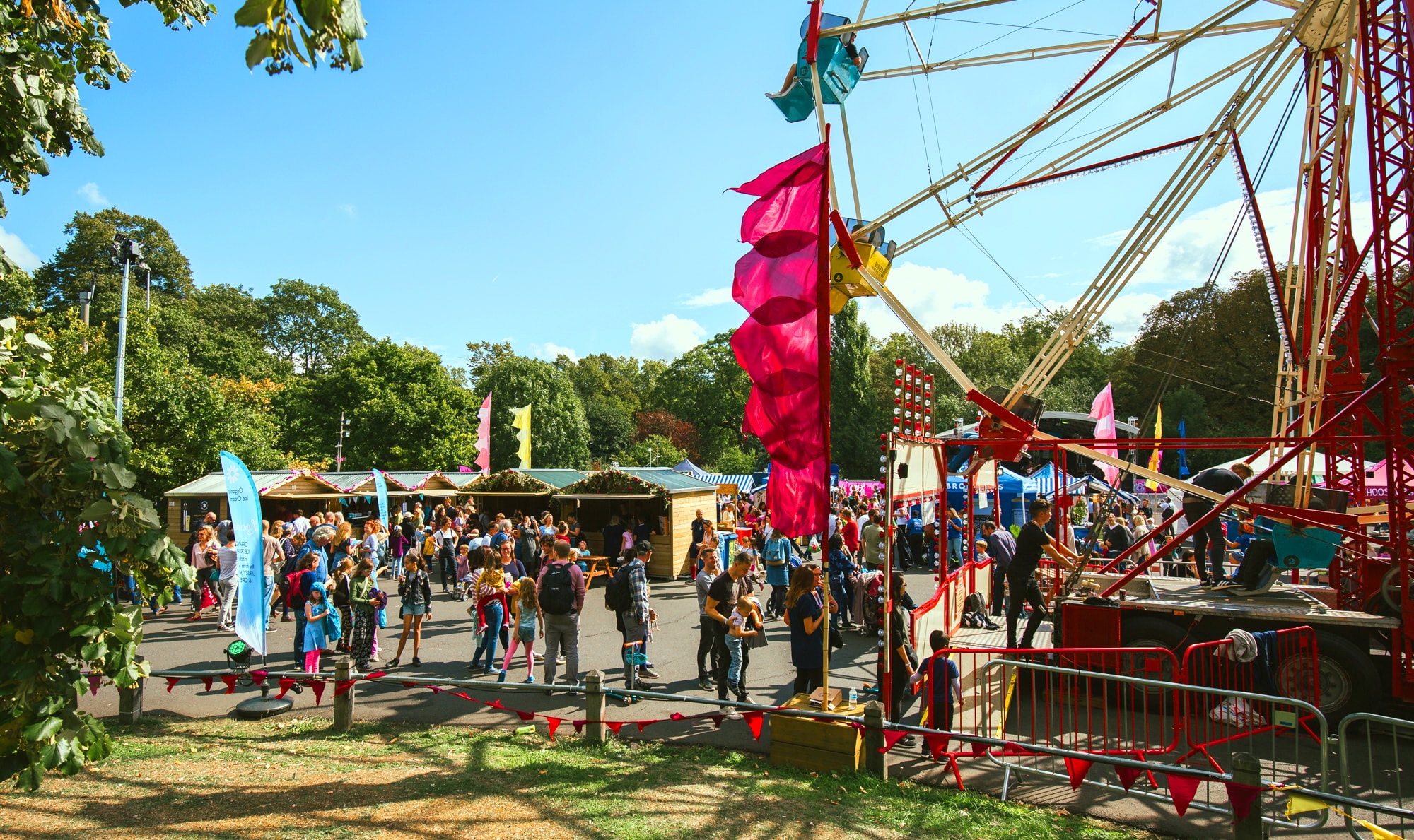 Vibrant outdoor summer event at Evolution London with colorful ferris wheel and festive atmosphere.