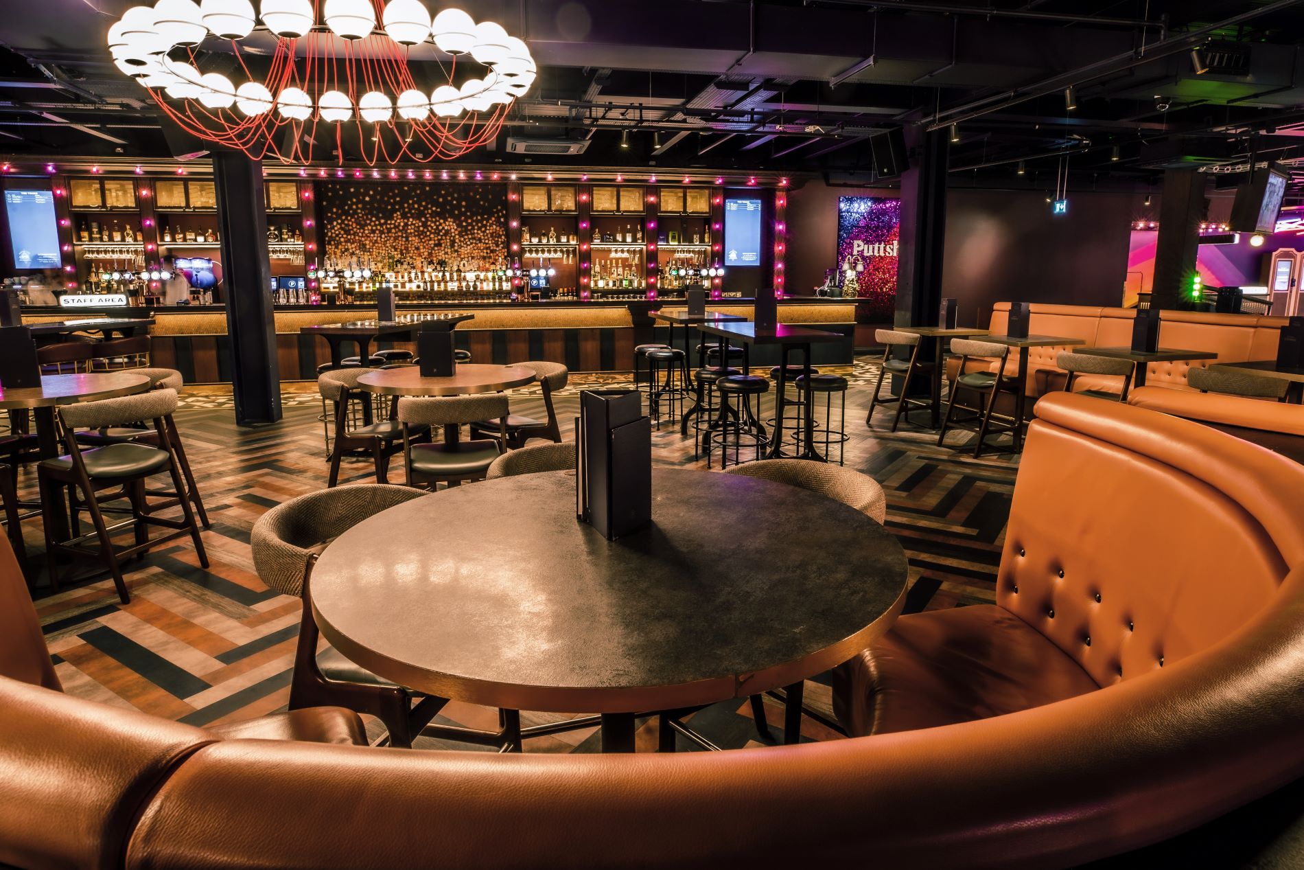 Stylish event space at Puttshack Watford with modern bar, ideal for networking and gatherings.