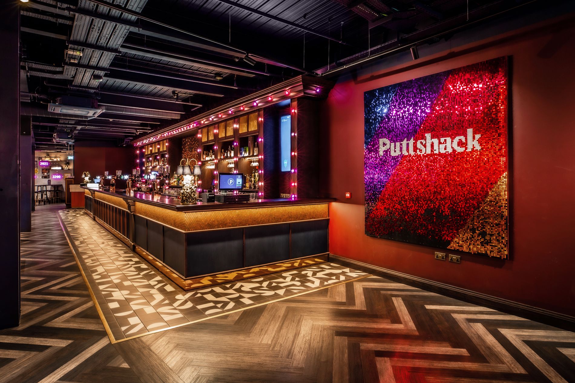 Vibrant Puttshack Watford venue hire with stylish bar for events and gatherings.