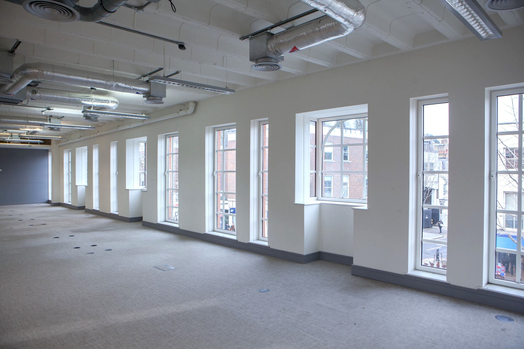 Spacious event space with large windows for meetings and workshops in Chelsea.