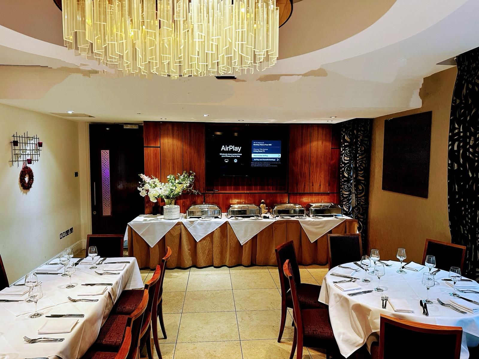 Elegant Bombay Palace suite with round tables, ideal for corporate events and gatherings.