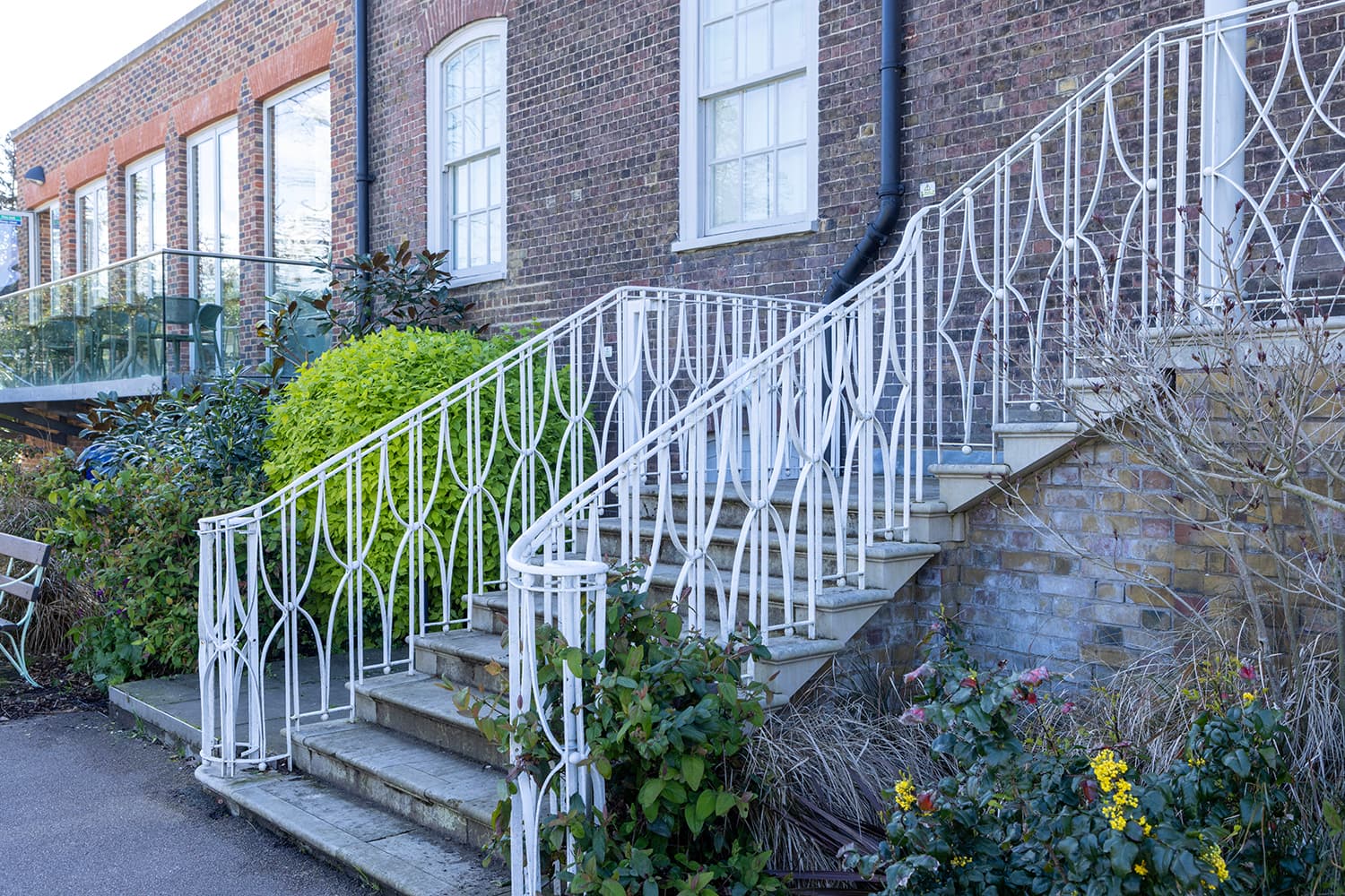 Elegant staircase with wrought iron railing at Glasshouse, ideal for outdoor events.