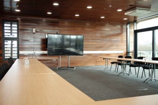 Modern meeting room with large table and display screen at Lee Valley White Water Centre.