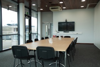 Modern meeting room with large table, ideal for corporate events and presentations.