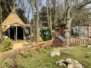 Charming teepee with balloons in lush outdoor event space for gatherings and parties.