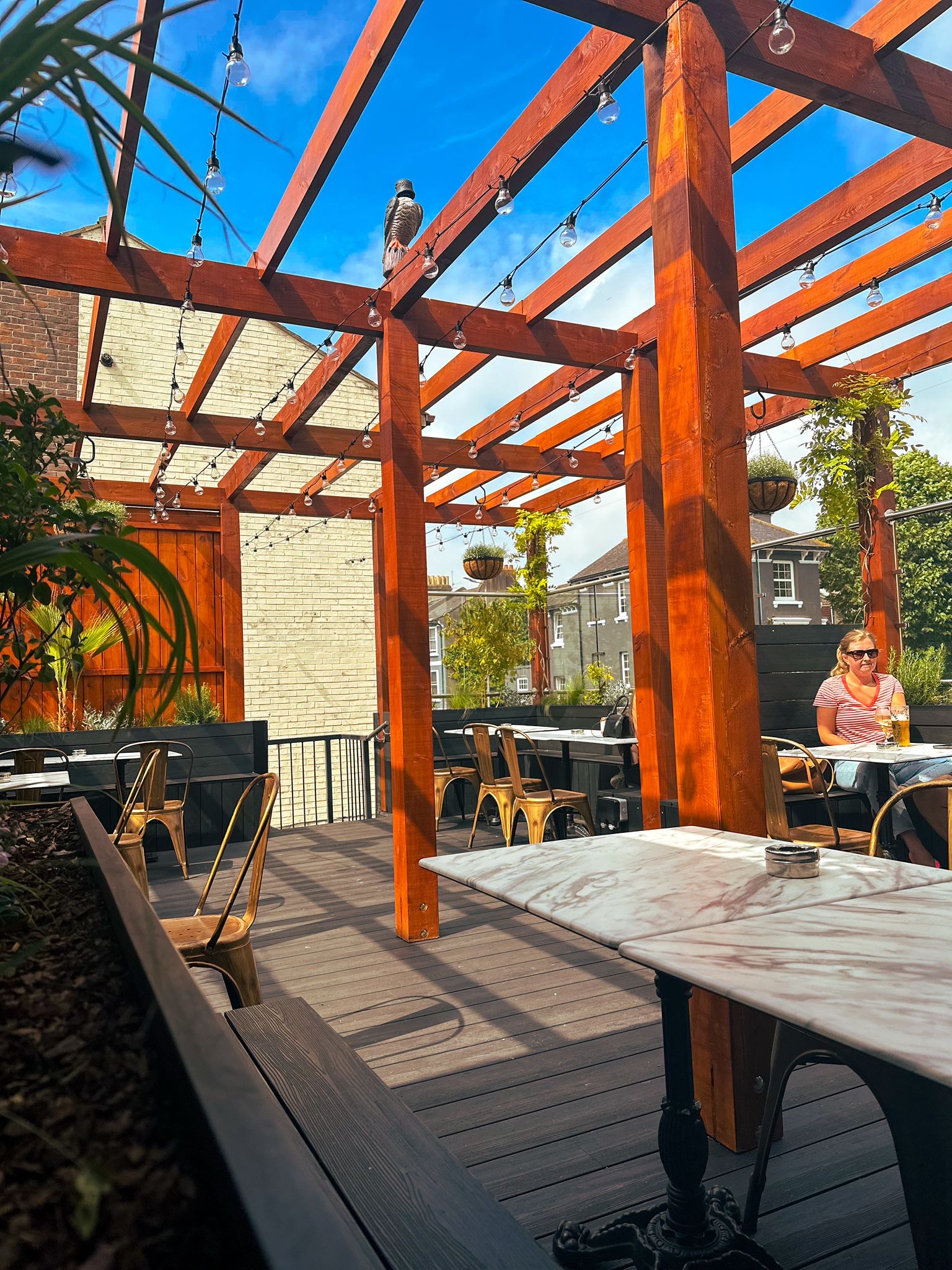 Stylish outdoor lounge with wooden pergola, perfect for networking events and casual meetings.