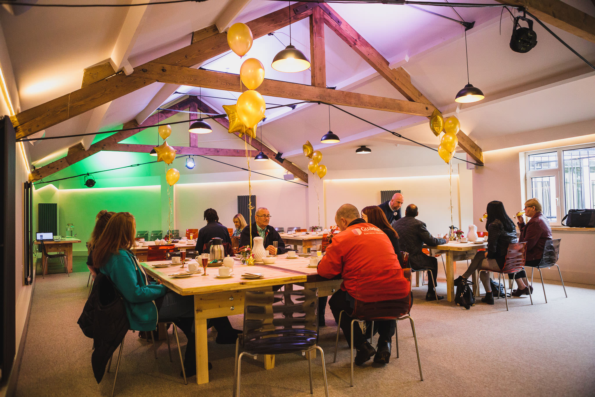 Event space with tables and balloons, perfect for workshops and networking.