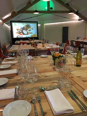 Intimate dining meeting space with elegant table setting and projector for presentations.