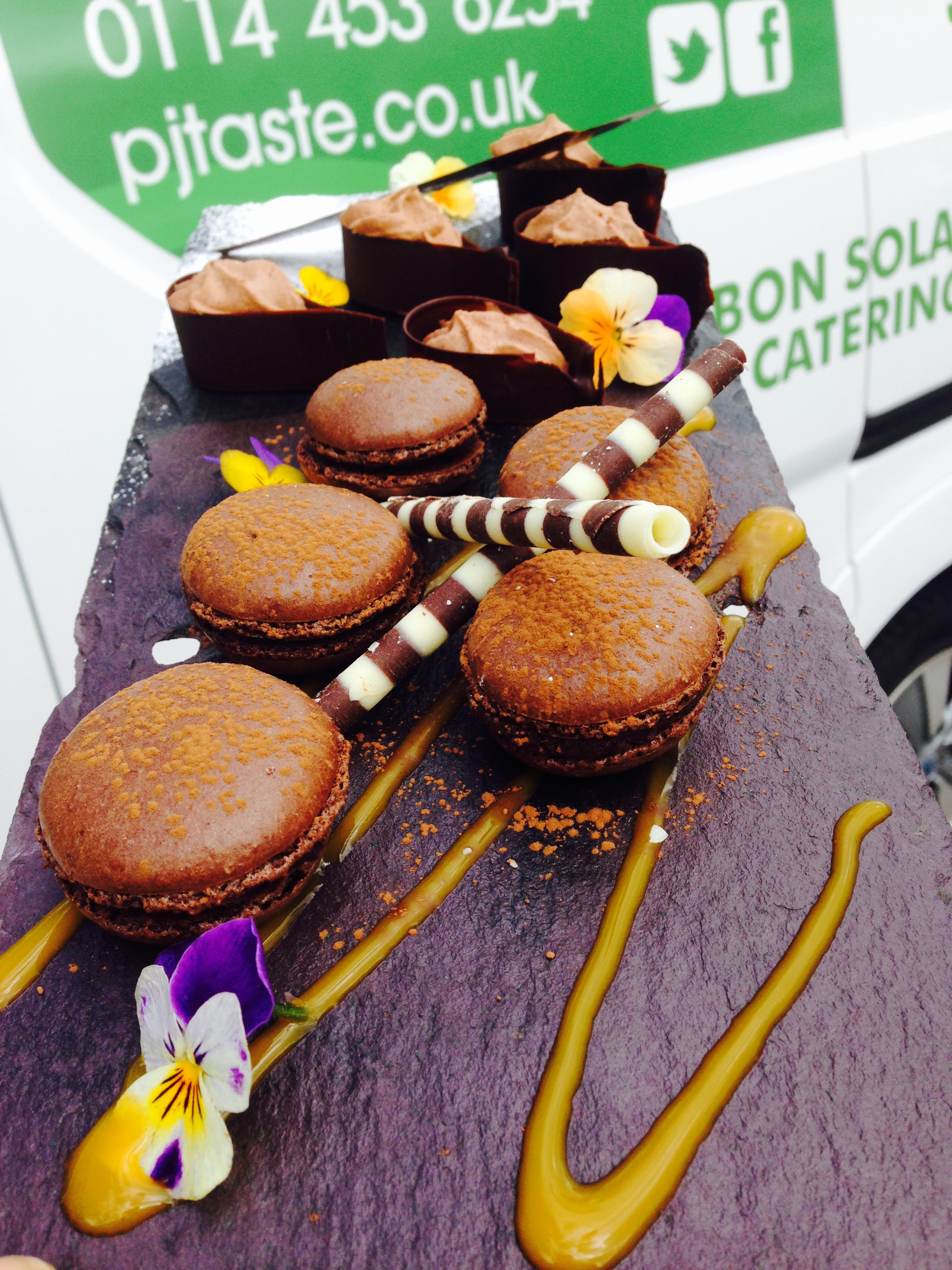 Elegant chocolate macarons display for upscale events and catering.