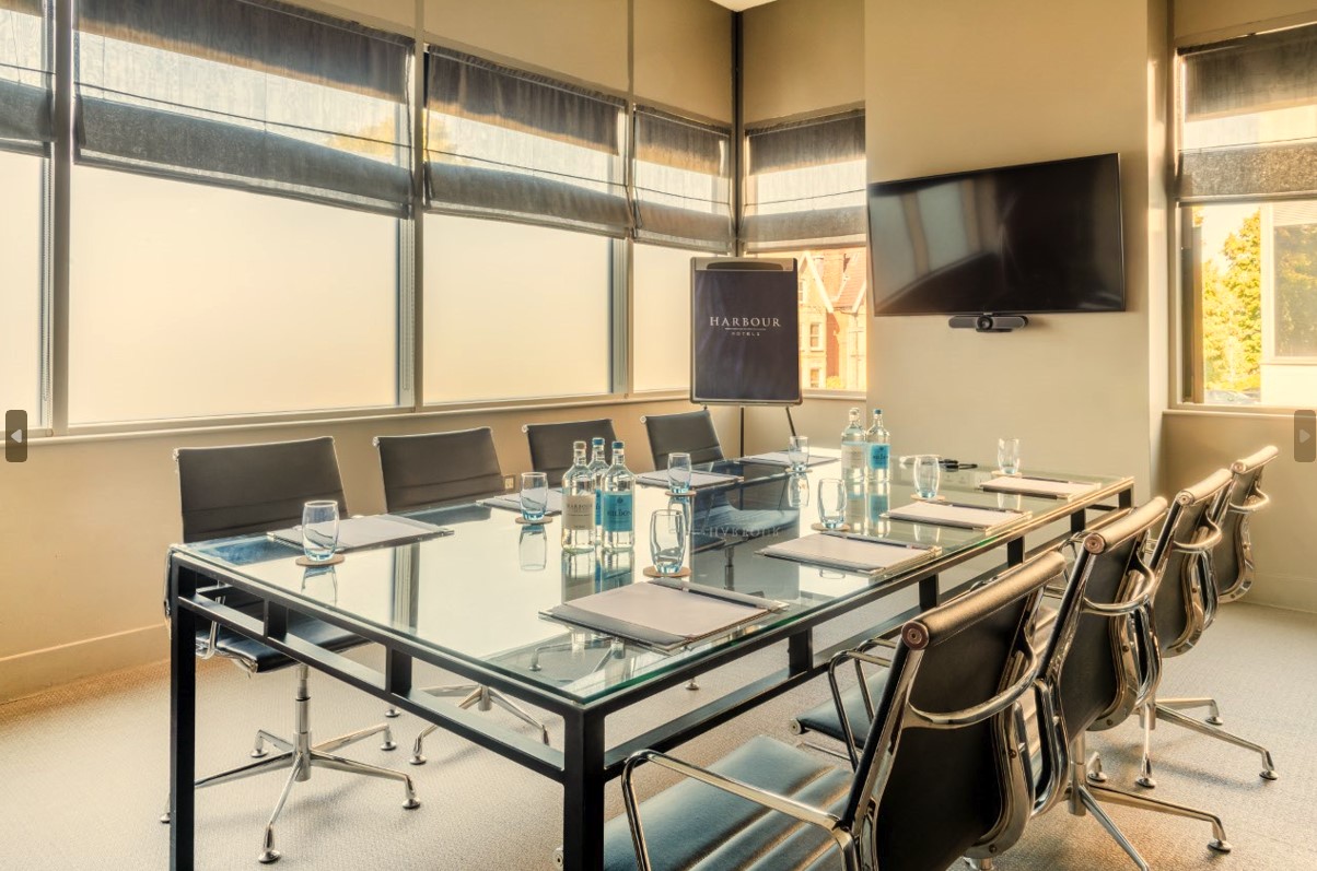 Modern conference room with glass table at Guildford Harbour Hotel for meetings and presentations.