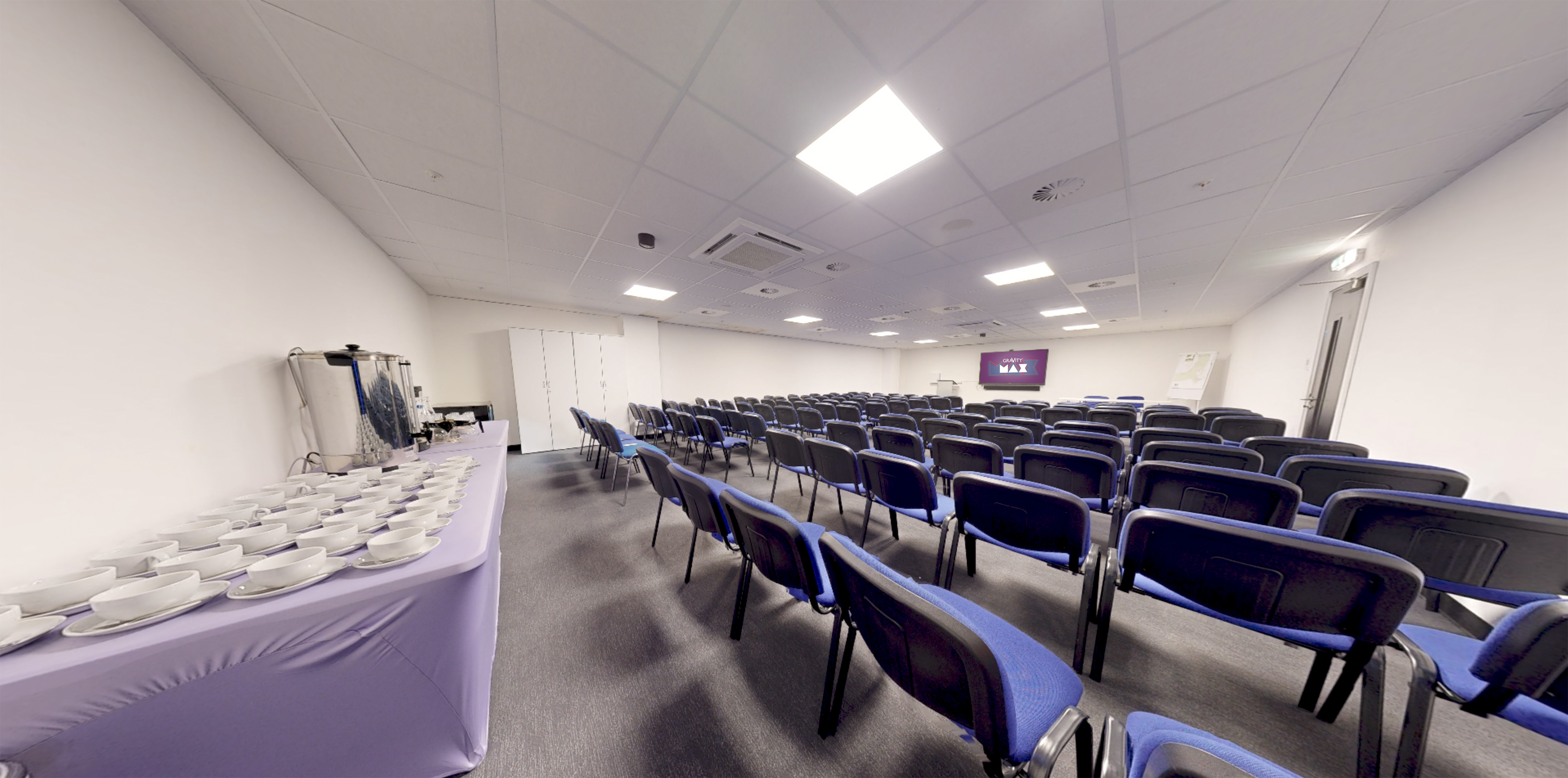Meeting Room at Gravity Max with blue chairs, ideal for presentations and workshops.