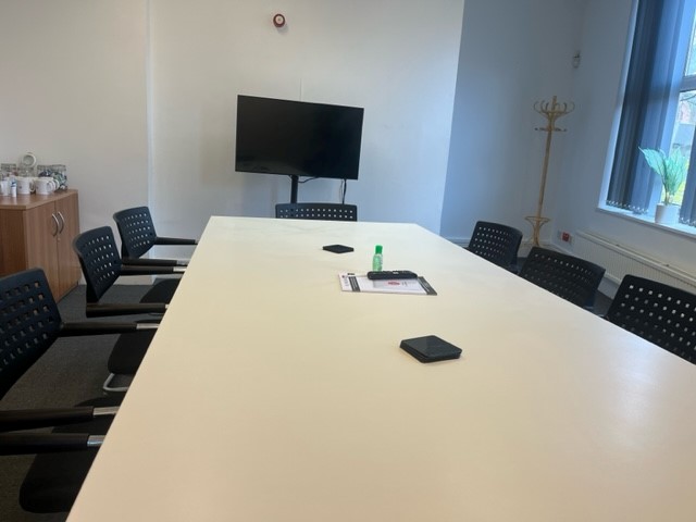Modern meeting room in Hamill House with white table and ergonomic chairs for collaboration.