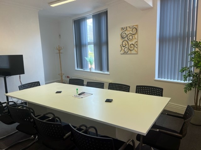 Modern meeting room in Hamill House with large table, ideal for team collaboration.