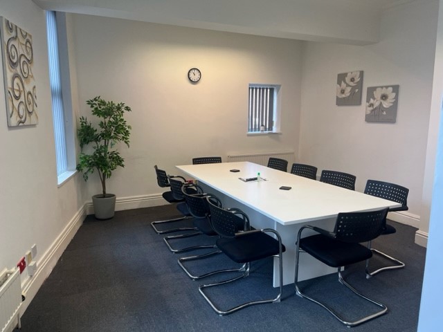 Minimalist meeting room in Hamill House with ergonomic chairs for productive workshops.