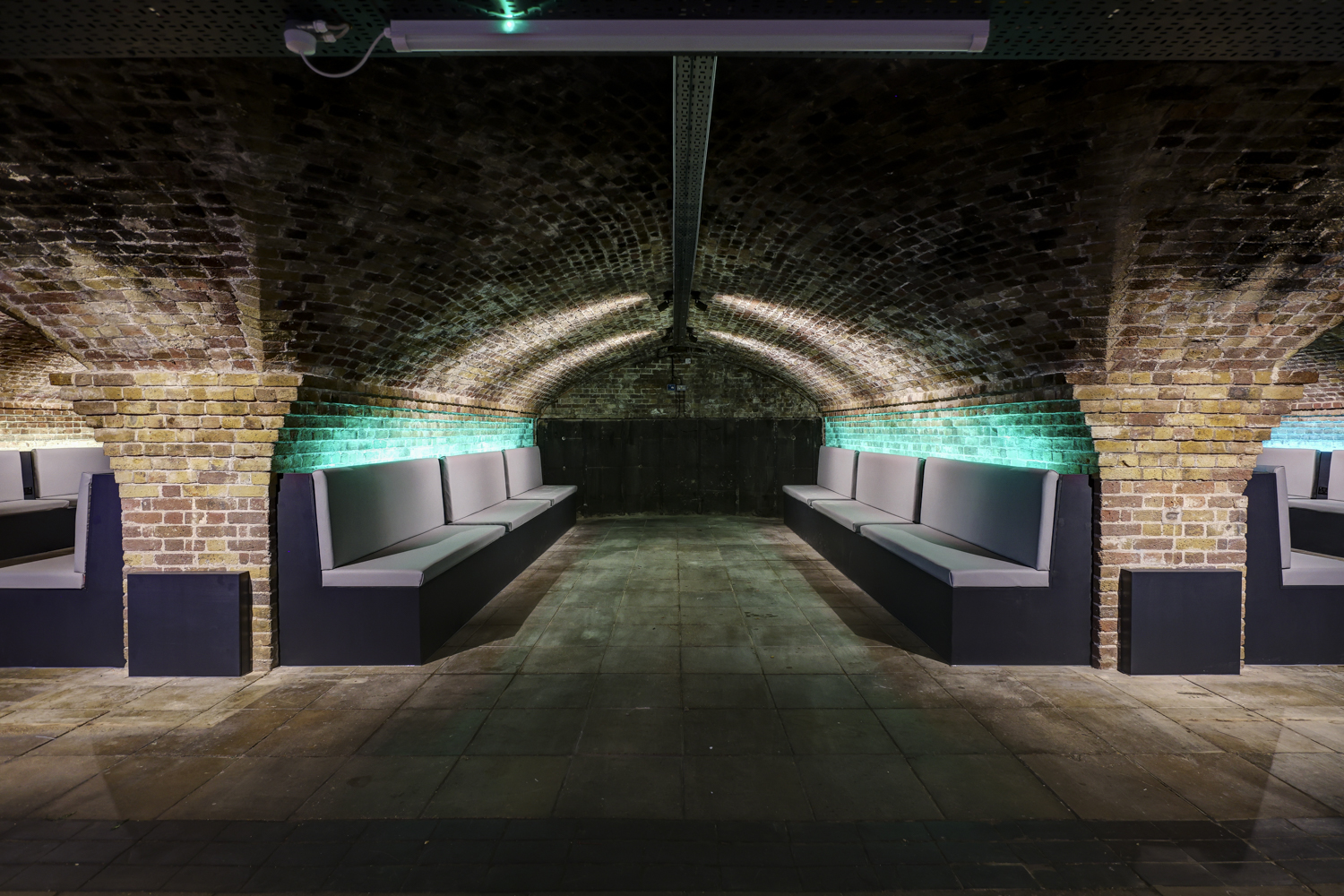 Stylish underground venue with arched ceilings for networking events and gatherings.
