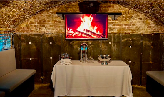 Cozy event space at Half Venue, Dockside Vaults with digital fireplace for gatherings.