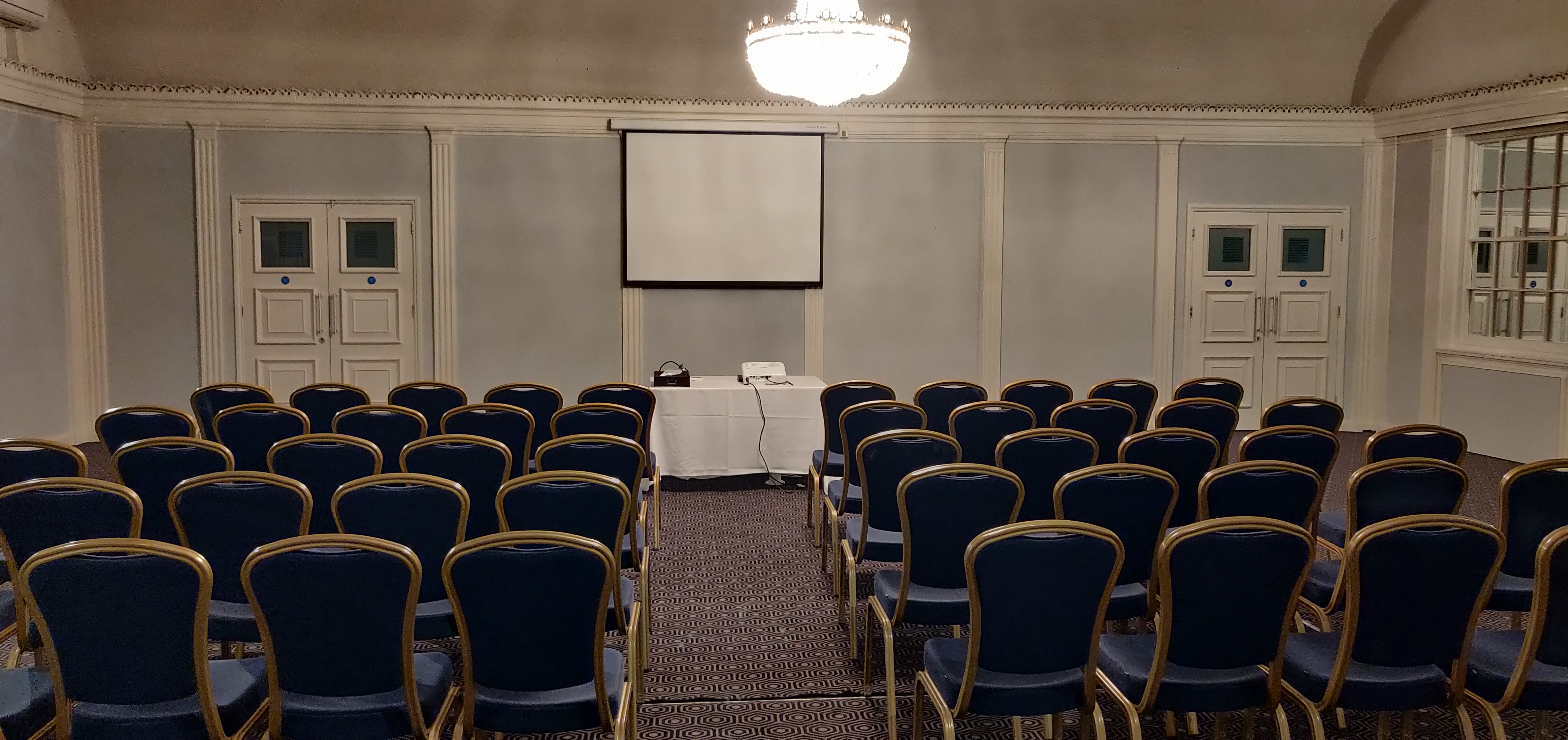 Elegant meeting room at ABode Hotel with blue chairs for presentations.