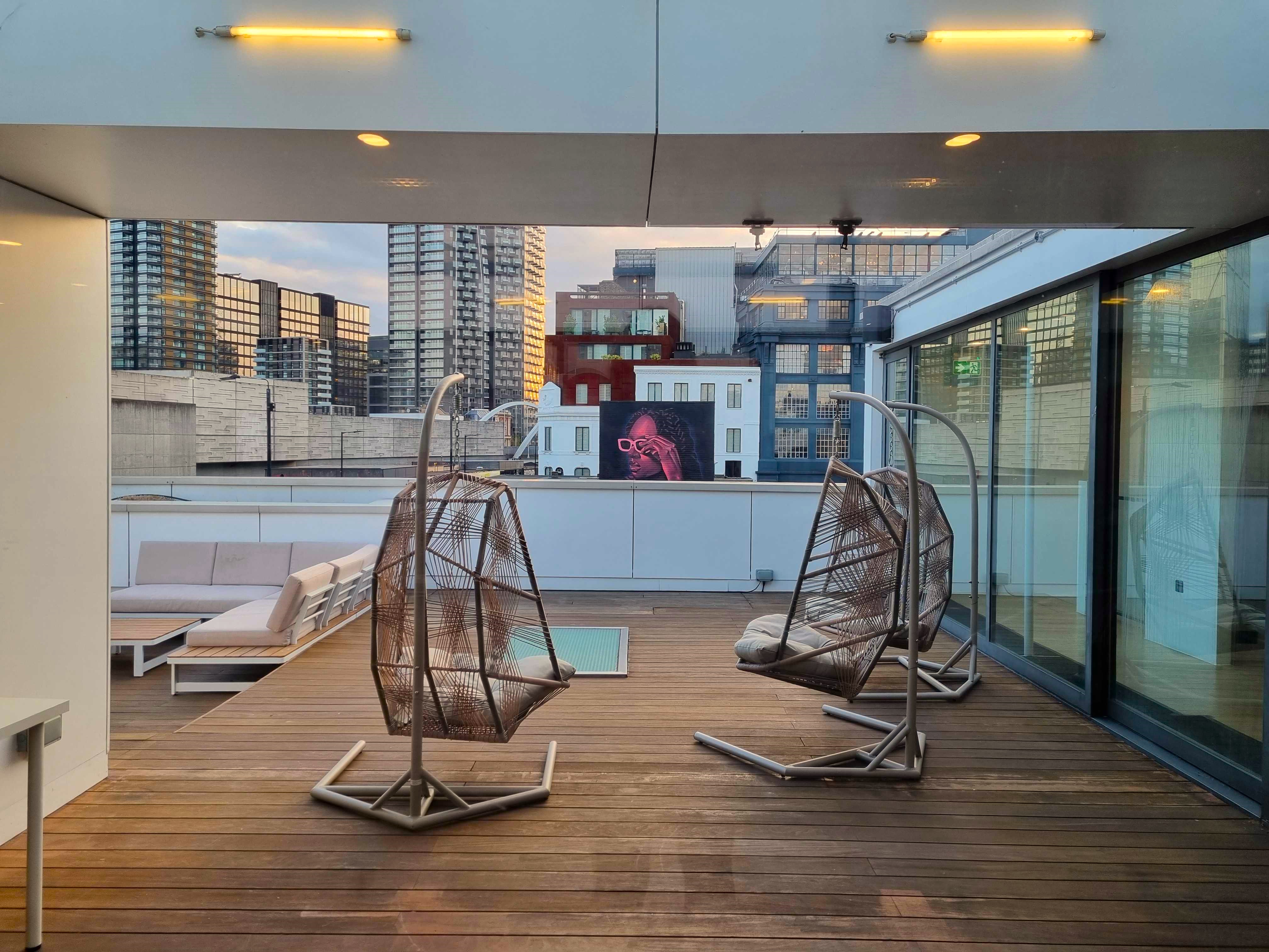 Stylish rooftop venue with hanging chairs for intimate gatherings and networking events.