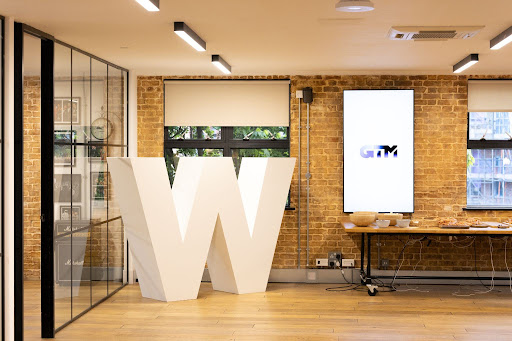 Modern EC1 Campus meeting space with bold "W" and glass walls for branding events.