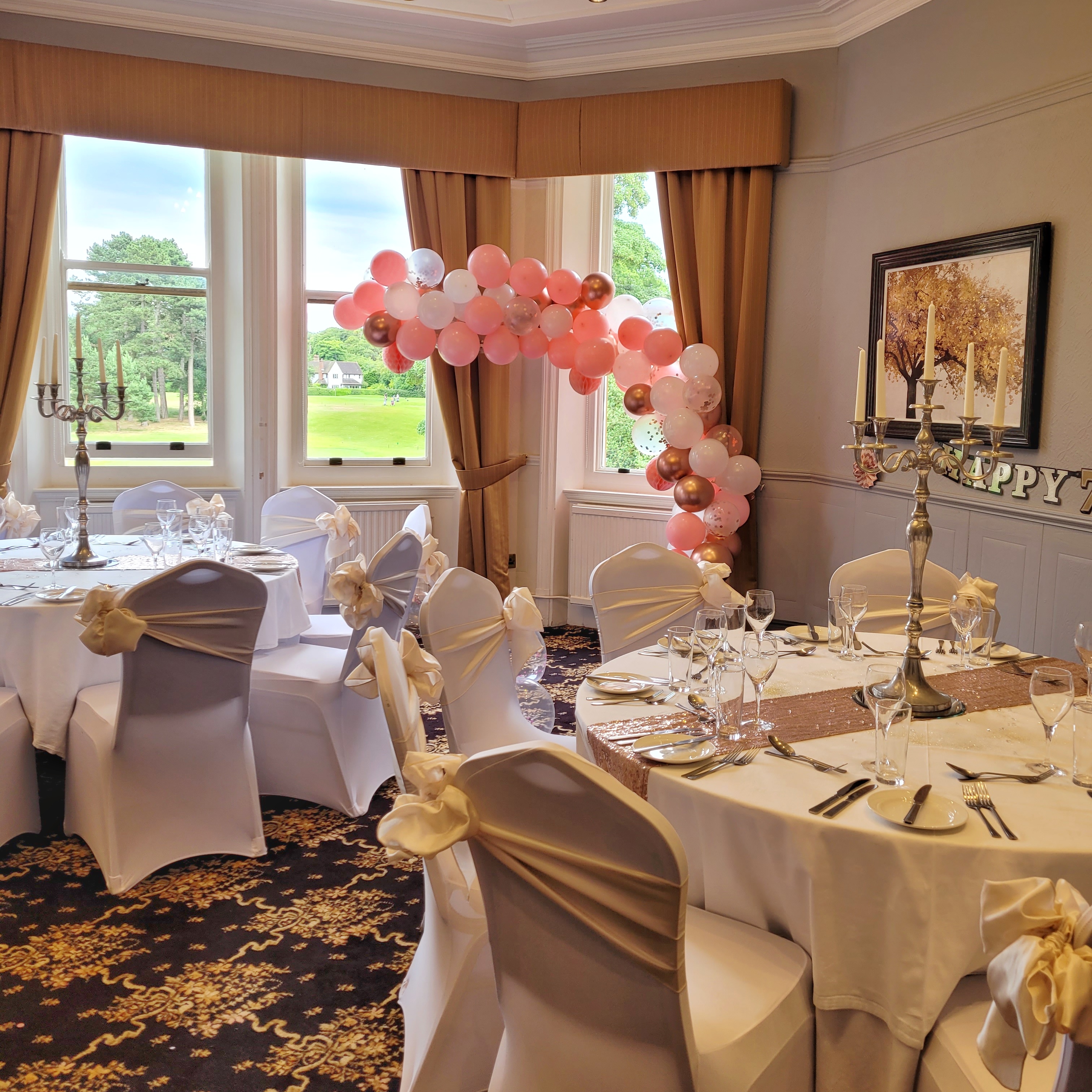 Elegant event space at Moor Hall Hotel with white tables and pink balloon arch.