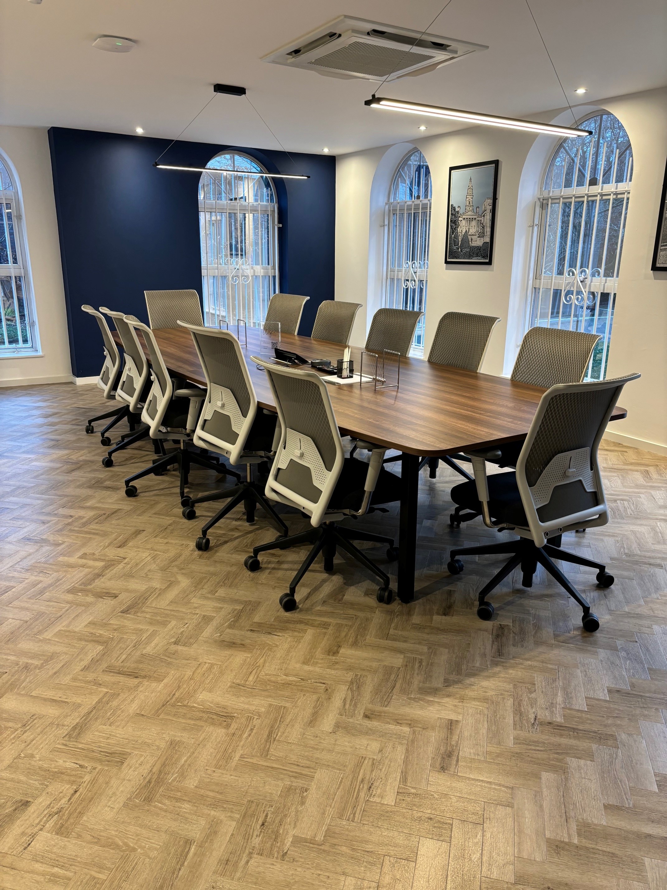 Modern conference room with wooden table and ergonomic chairs for meetings and presentations.