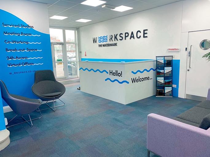 Modern co-working space reception with blue accents, ideal for meetings and events.