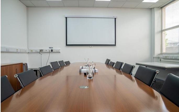 Boardroom at The Watermark with wooden table, ideal for professional meetings and presentations.