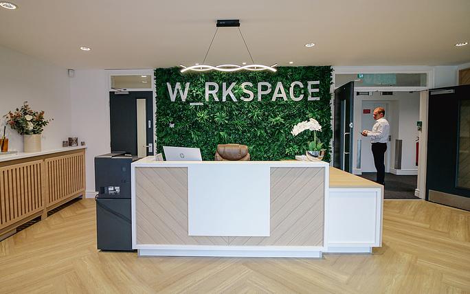 Modern meeting room with green wall, ideal for events and networking.