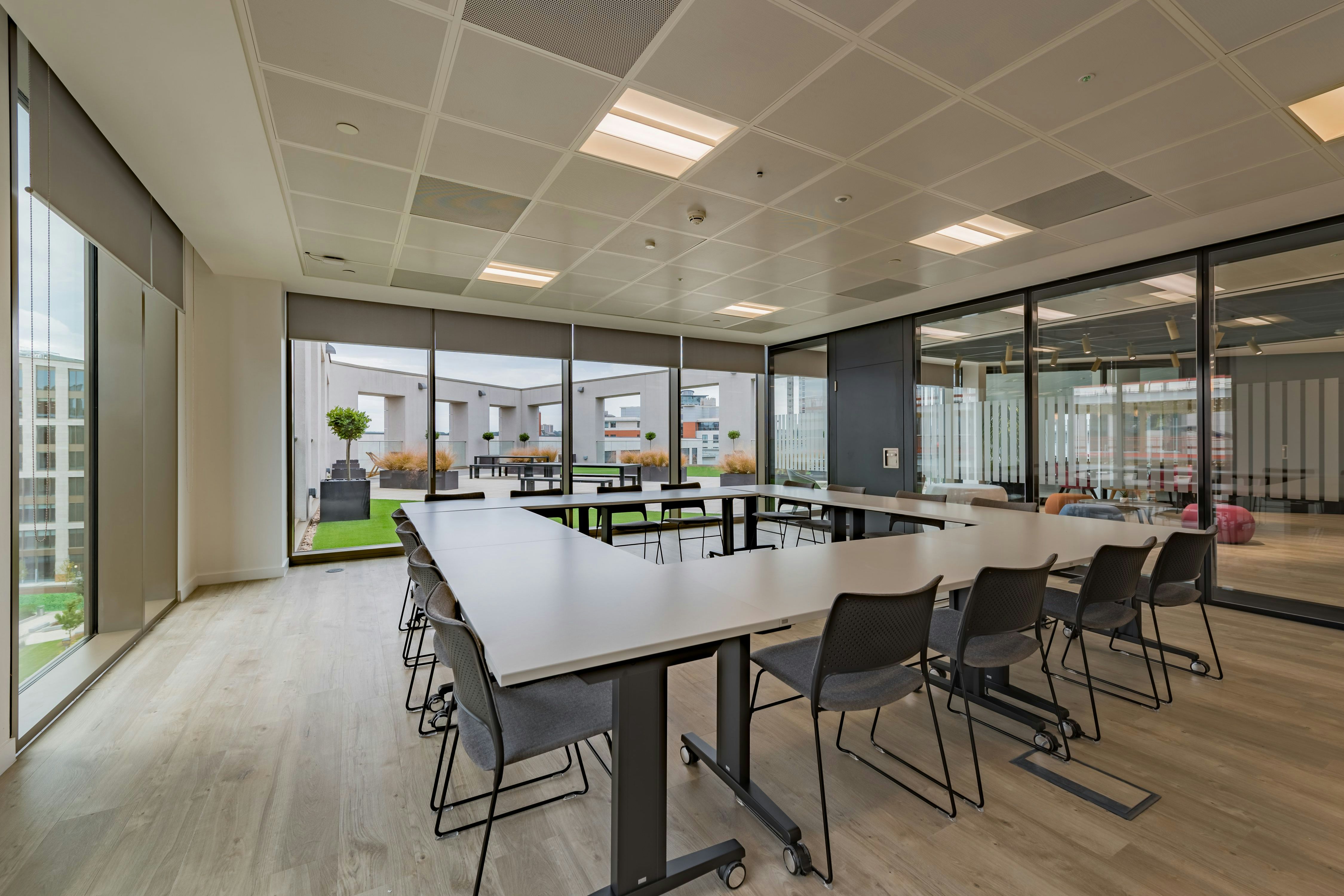 Modern meeting room with large windows, perfect for workshops and team meetings.