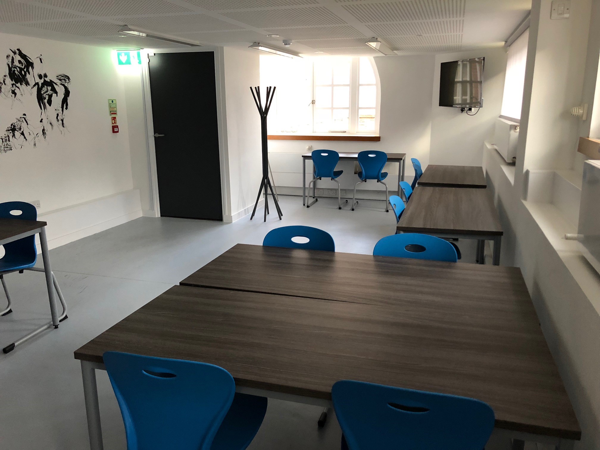 Versatile meeting space with blue chairs for workshops at Institut français du Royaume-Uni.