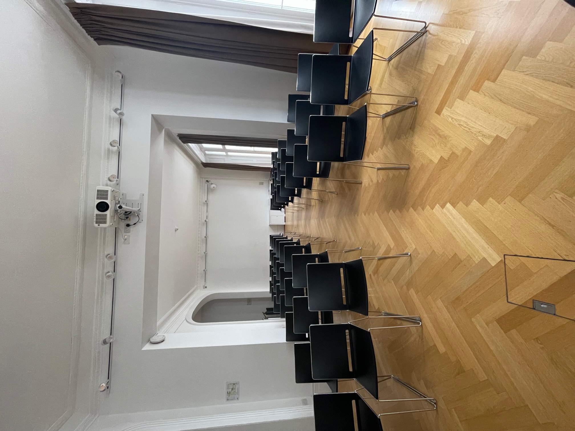 Les Salons meeting space with black chairs, ideal for workshops and presentations.