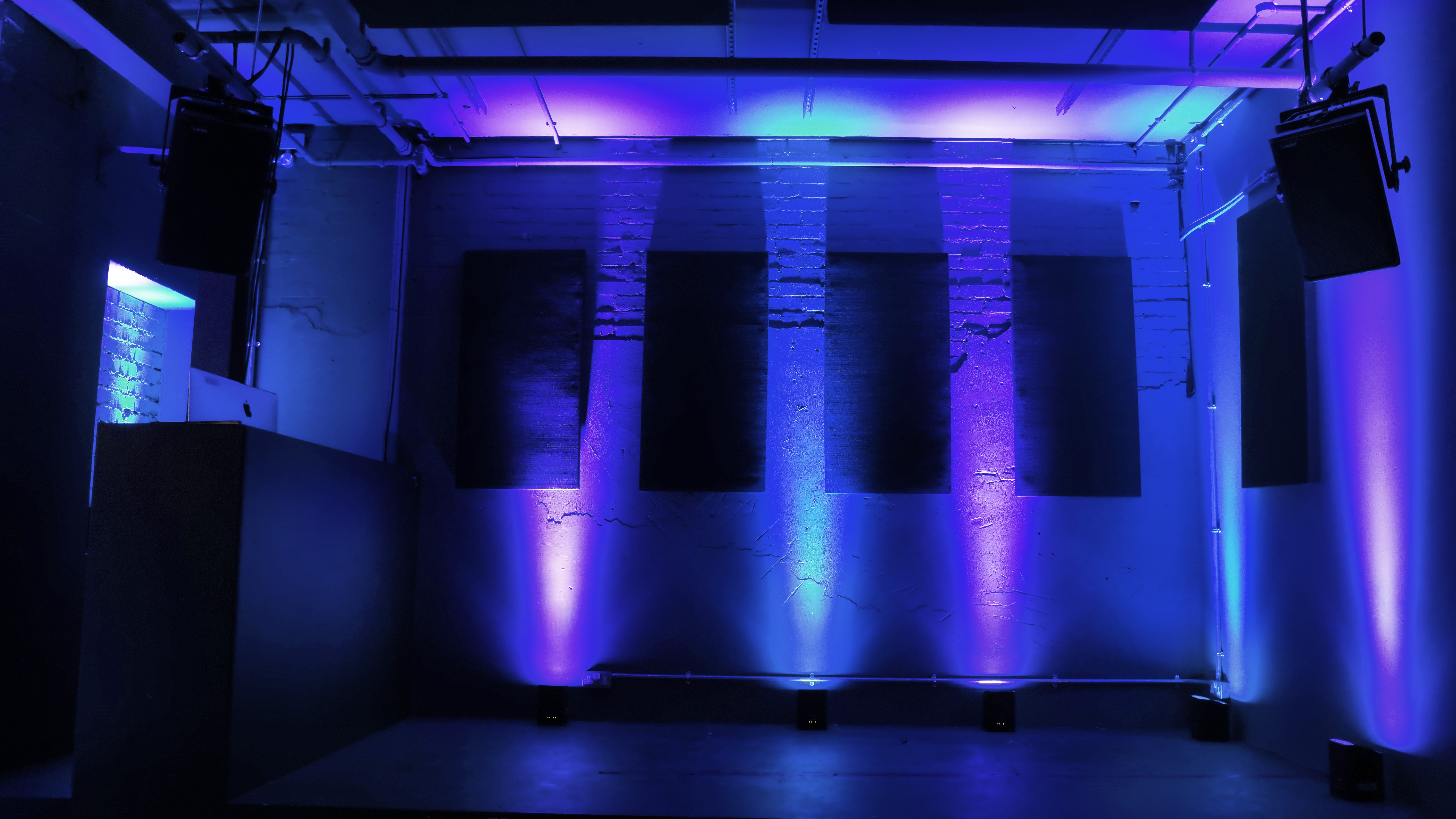 Modern event space with blue lighting, ideal for corporate meetings and creative events.