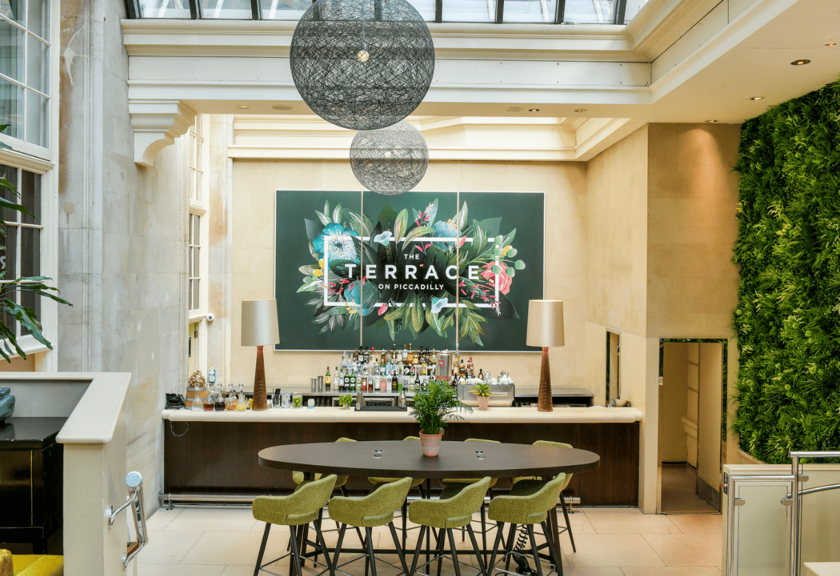 Stylish event space at The Dilly with modern bar and lush greenery for networking events.