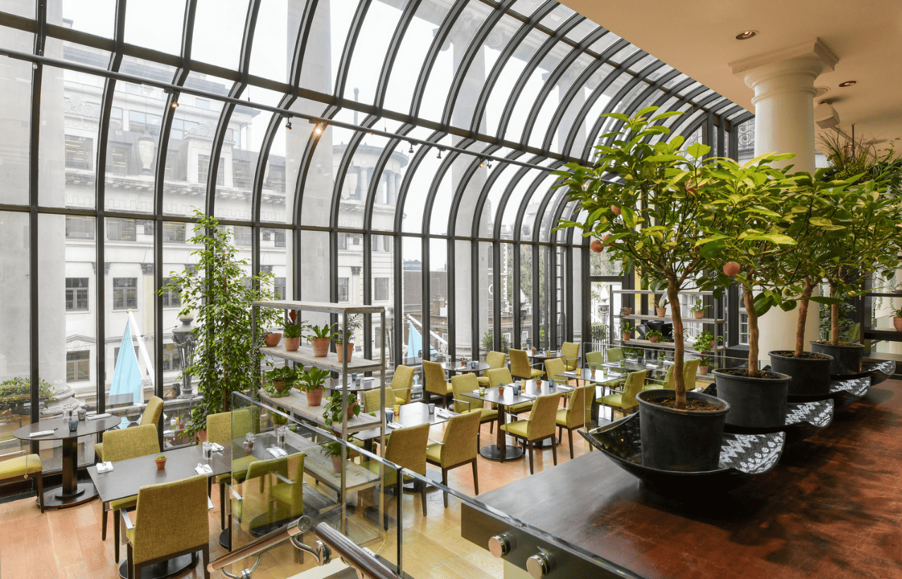 Modern restaurant with glass atrium, perfect for networking events and business lunches.