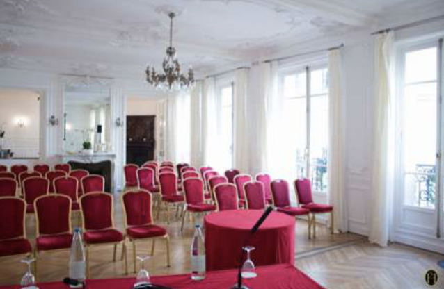 Elegant meeting room with red chairs, ideal for presentations at Les Salons Hoche.