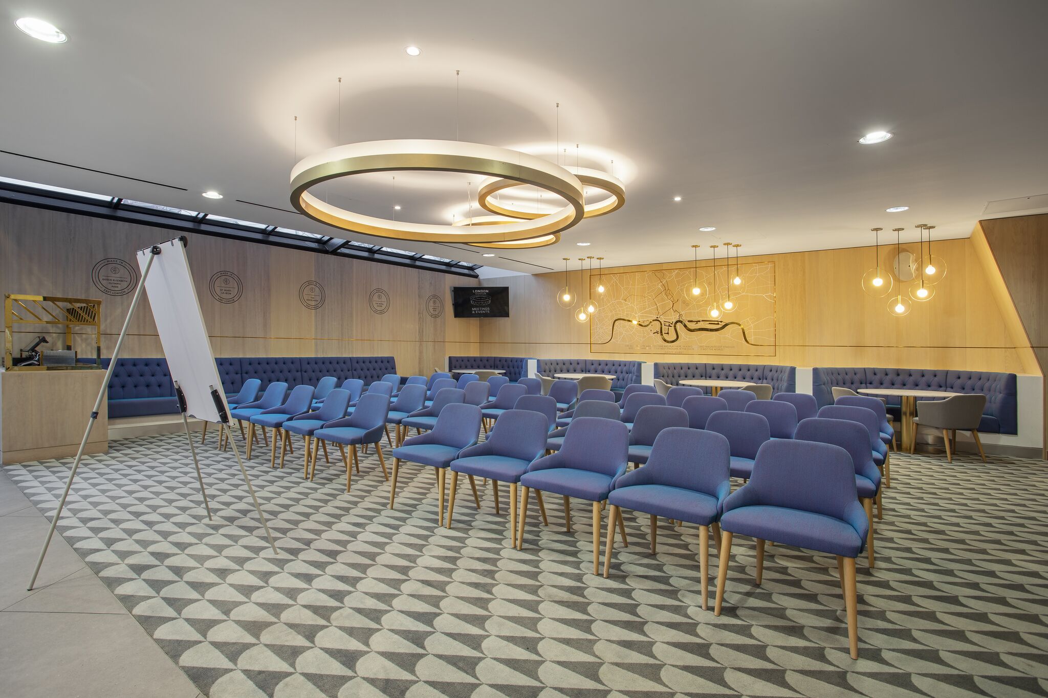 Modern meeting space at The Royal East, featuring blue chairs and stylish lighting for workshops.