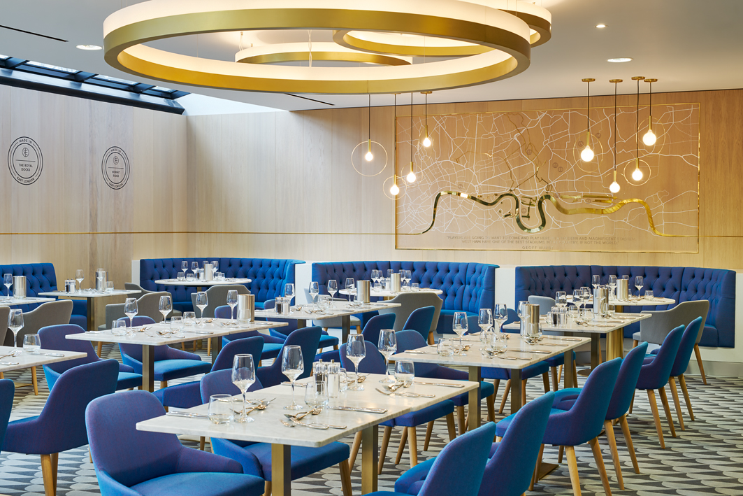 Modern event space at The Royal East, featuring blue seating for corporate gatherings.