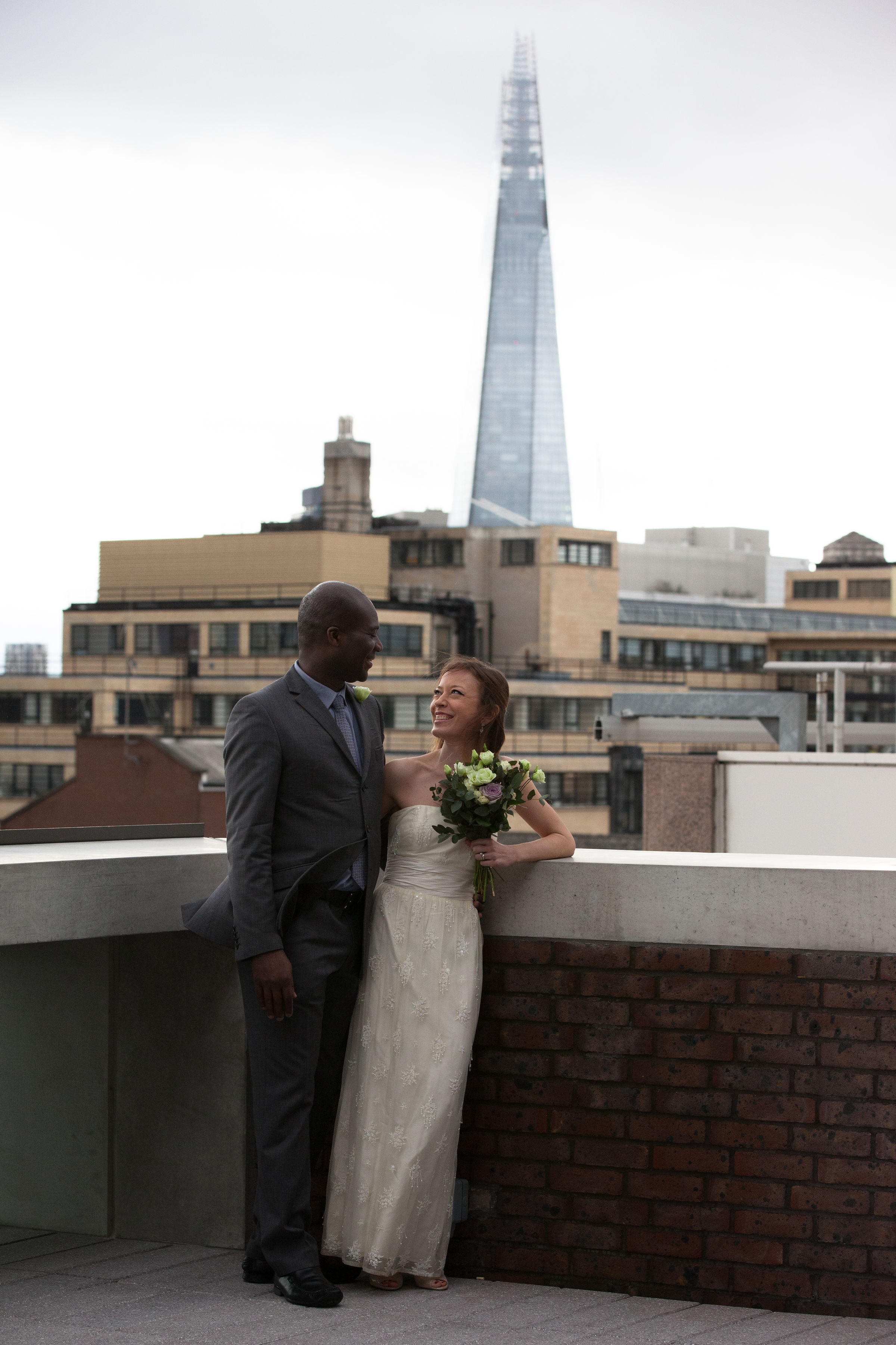 Couple celebrating wedding on rooftop with urban skyline, perfect for intimate ceremonies.