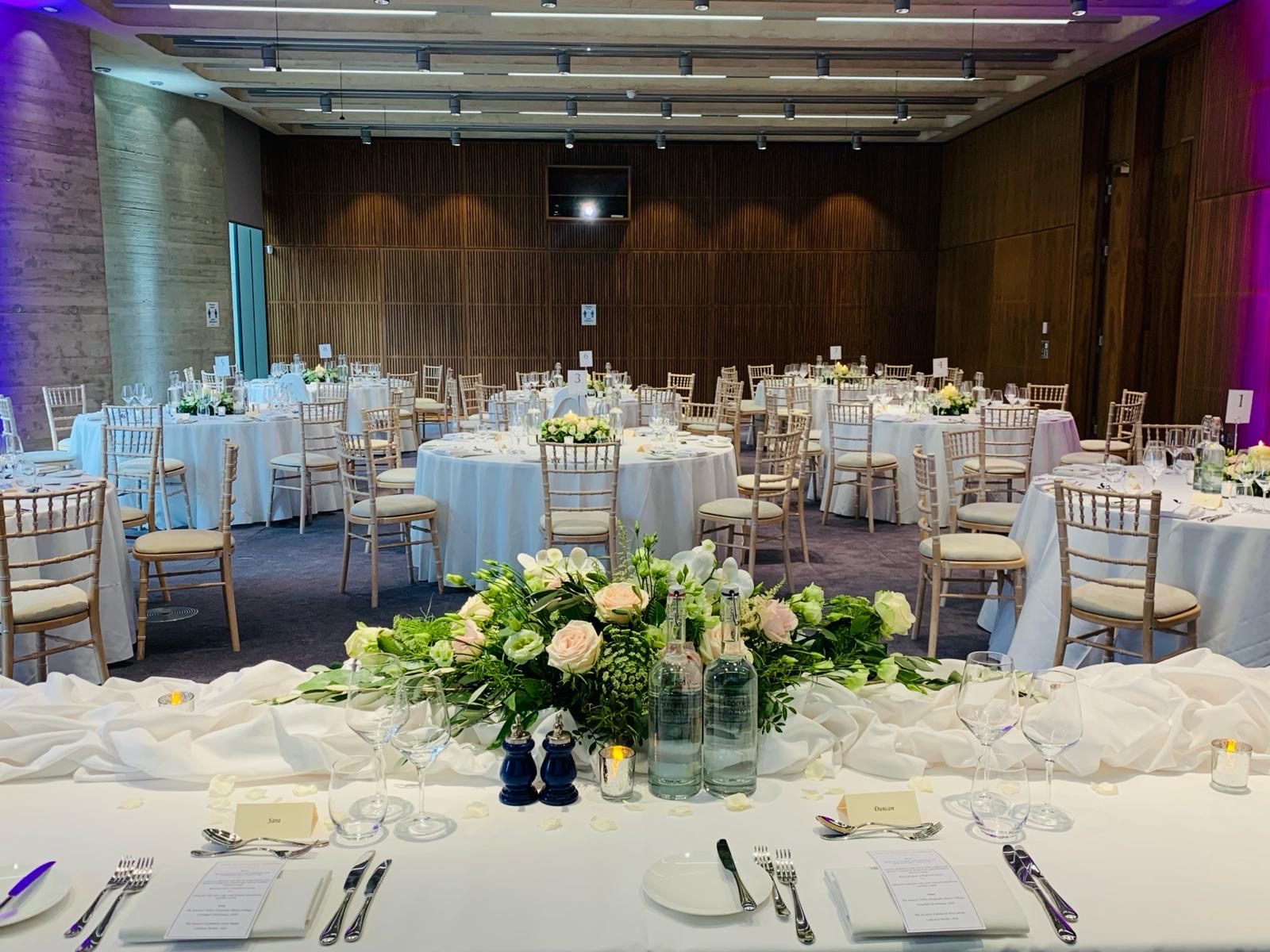 Elegant wedding venue with round tables and floral centerpieces, perfect for formal events.