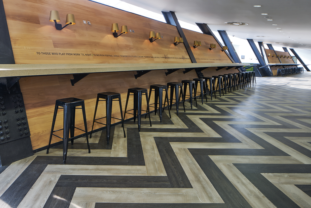 Modern event space in London Stadium with chevron floor, ideal for networking and gatherings.