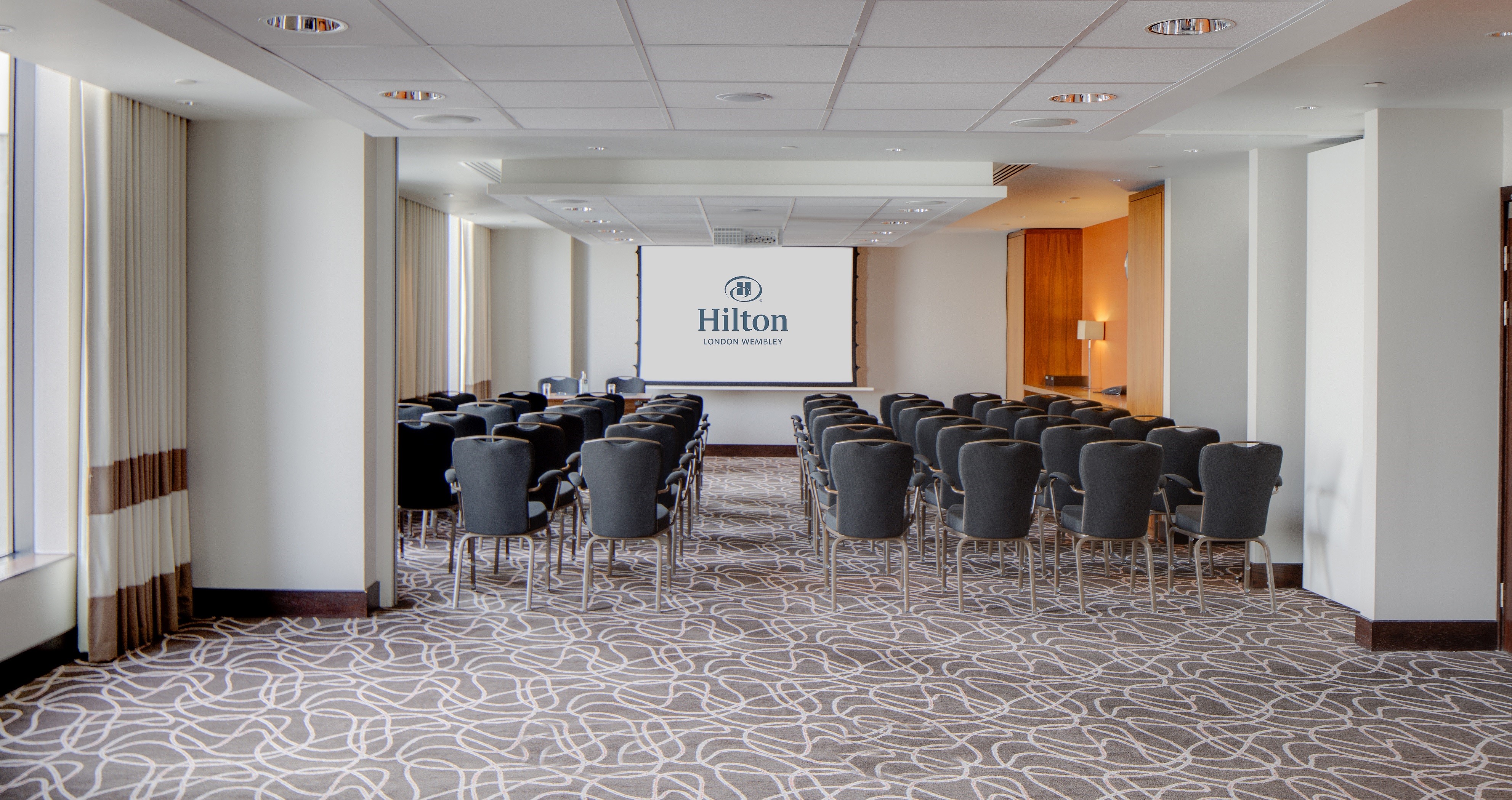 Spacious Hilton London Wembley meeting room with modern design for corporate events.