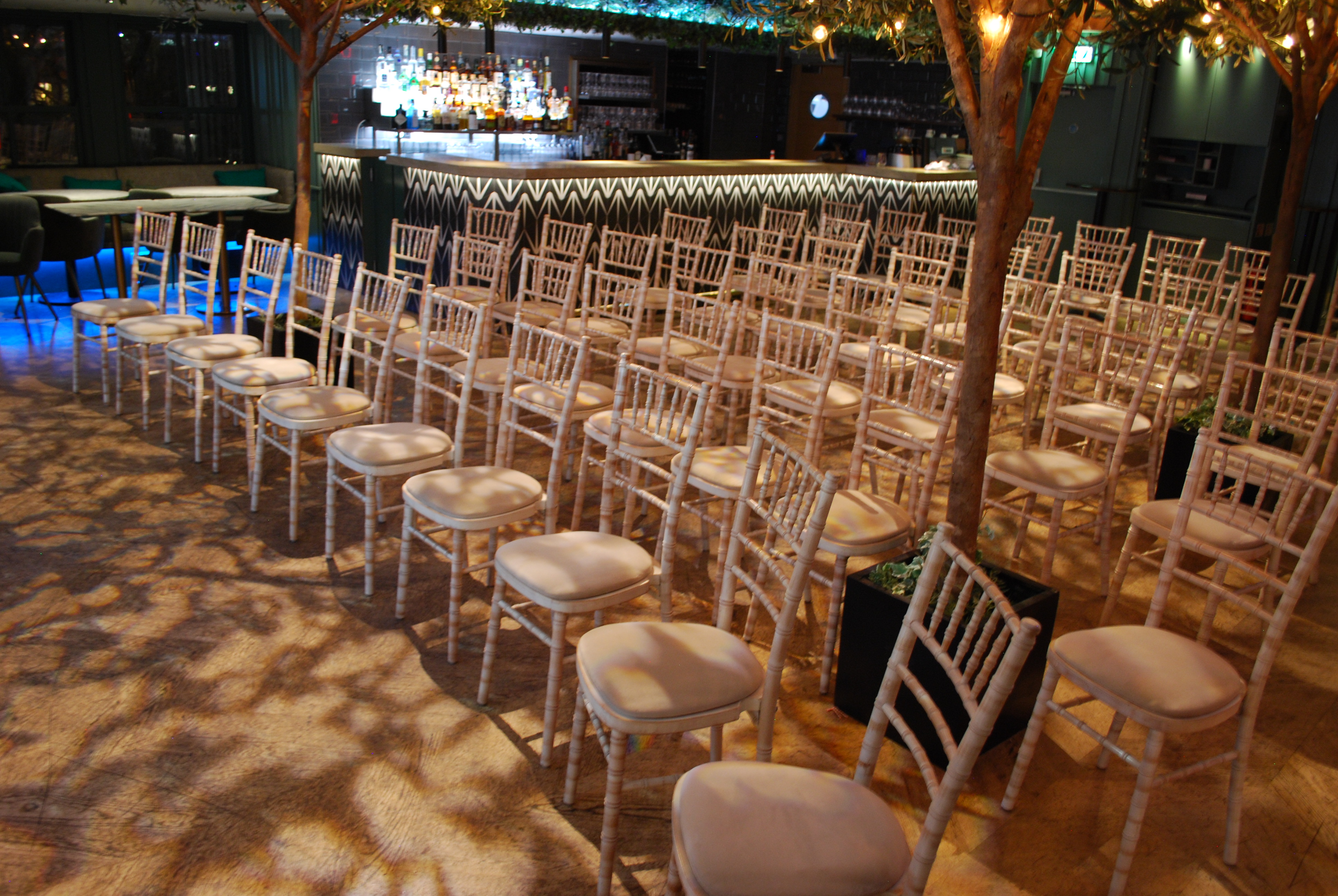 Roof terrace conference with elegant white chairs and ambient lighting at Century Club.
