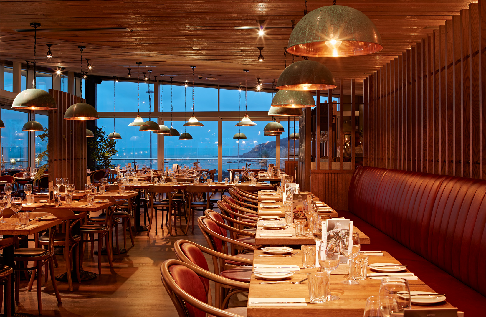 Modern restaurant interior with warm lighting, ideal for corporate events and gatherings.