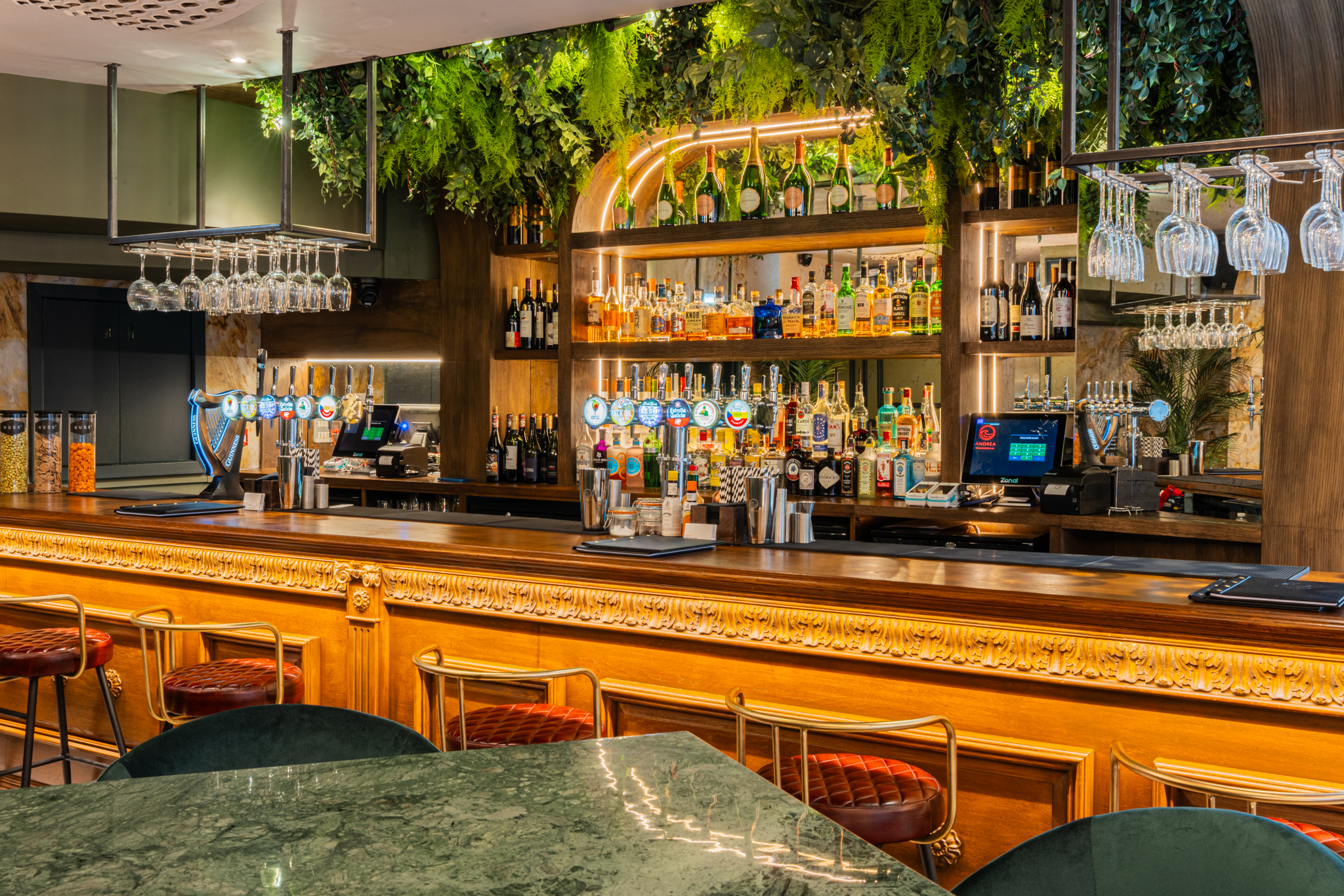 Stylish bar area with lush greenery, perfect for networking events and cocktail receptions.