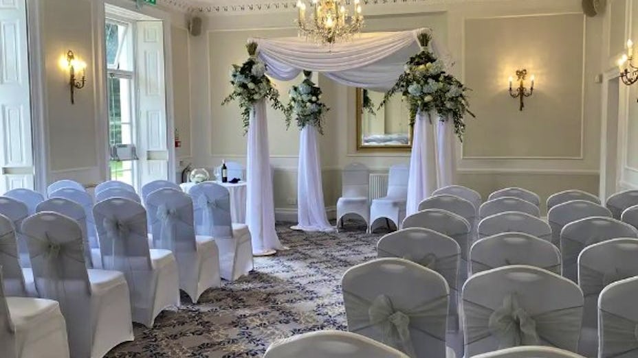Elegant Grand Hall at Dyrham Park, ideal for weddings with floral decor and soft lighting.