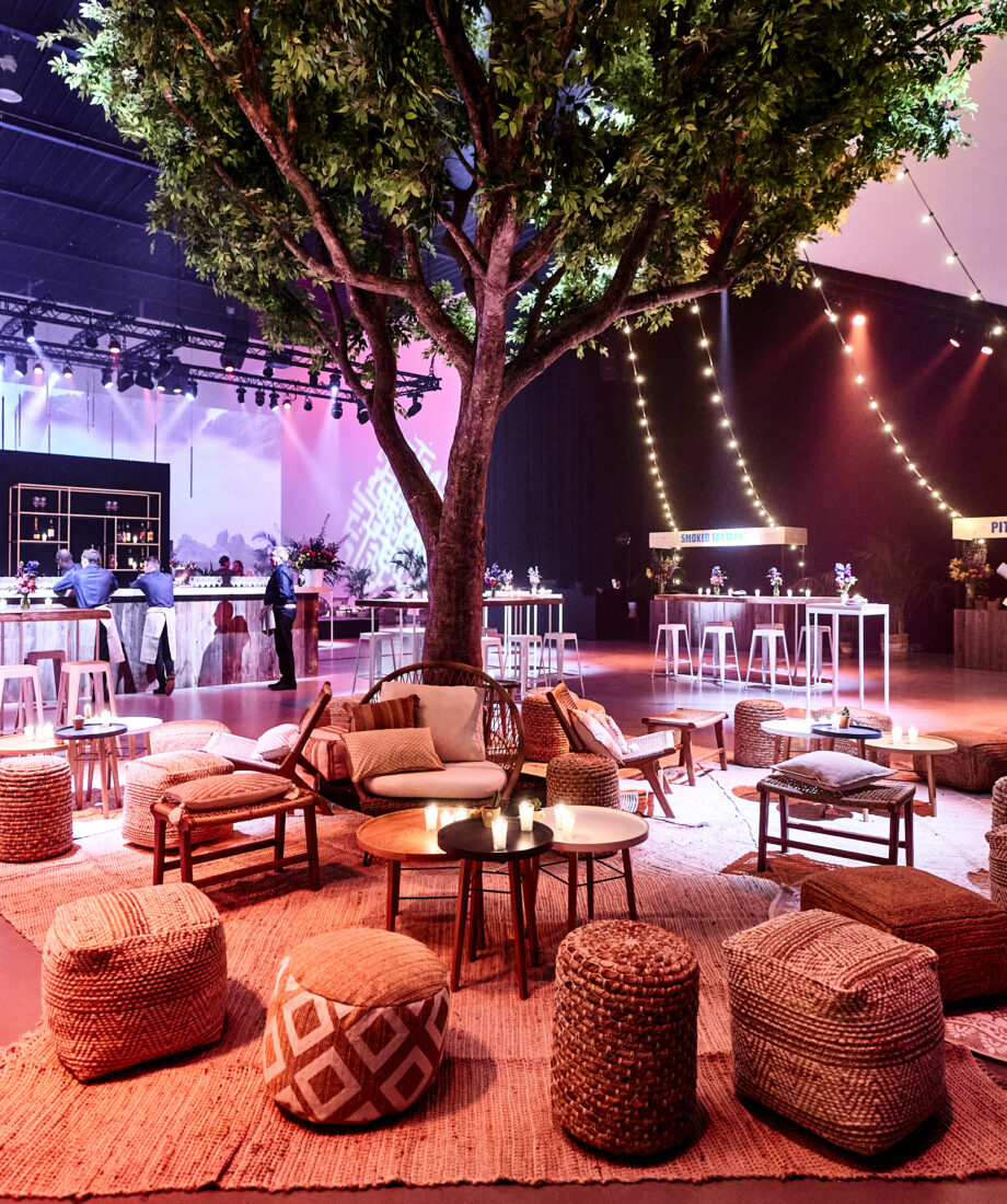 Stylish event space with central tree, perfect for networking and socializing.